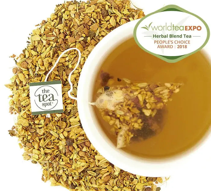 Turmeric Tonic tea in a cup with loose leaf tea around it